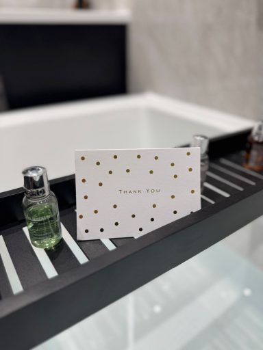 Finished bathroom detail with black bath caddy and luxury toiletries showing customer care from Kent plumbing and bathroom fitting company